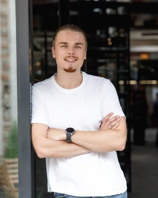 Egor Nefedov se zkříženýma rukama opřený o rám dveří