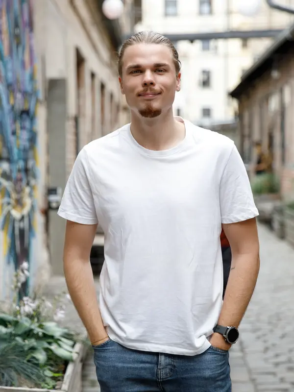 Egor Nefedov v bílém tričku na dlážděné pražské ulici